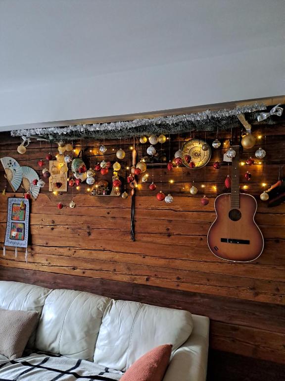 Lesena stena z okraski in kitaro nad kavčem